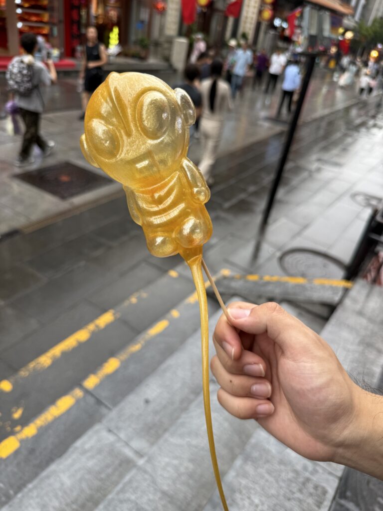 湿街背景前，一只金色的糖人。