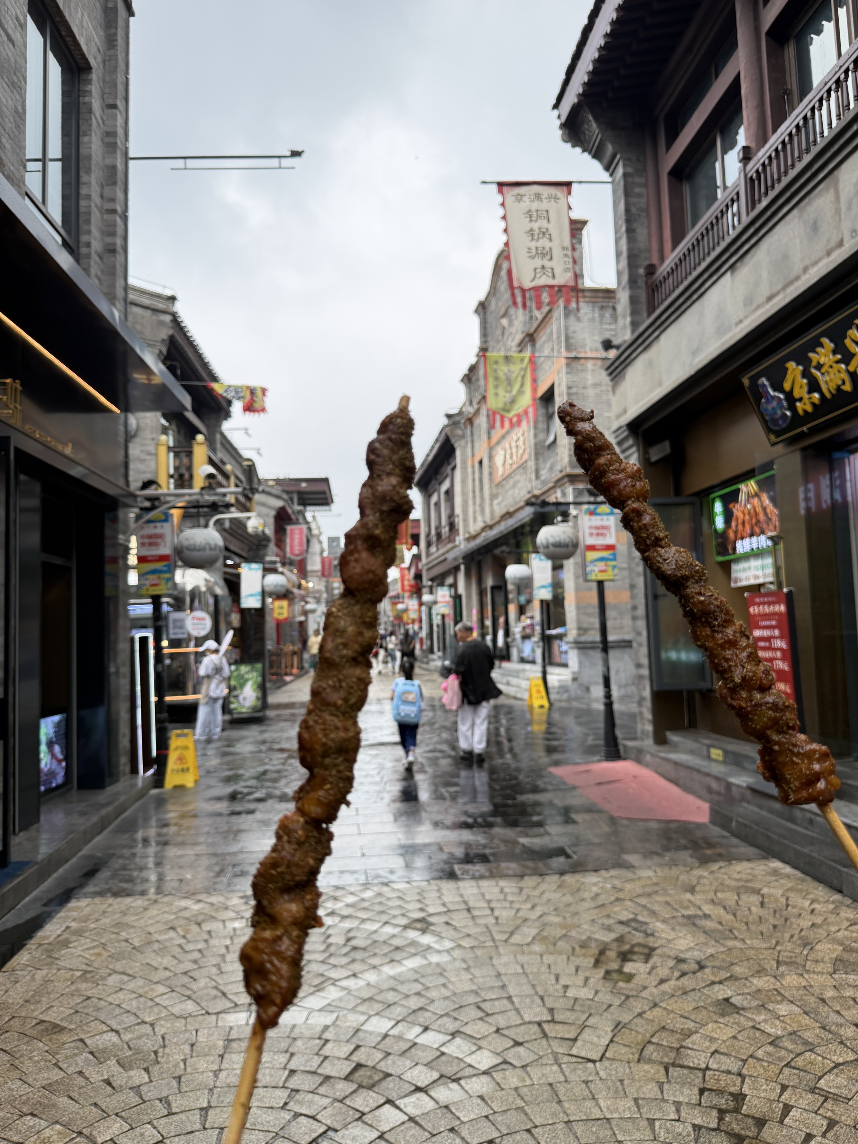 Grilled skewers raised in front of the old street.