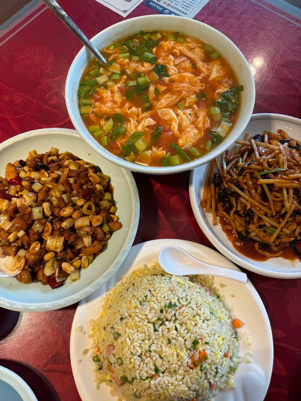 A warm meal with fried rice, soup, and several dishes.