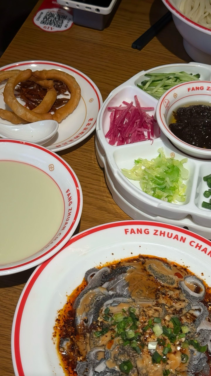 A Beijing-style meal with rich sauce, sides, and soup.